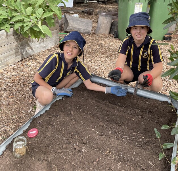 Imogen and Lizzie planting seeds in the new garden beds